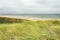 Typical dutch coastal landscape with sea, beach, waves, horizon, marram grass