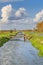 Typical Dutch flat polder landscape with cana and bridges