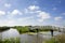 Typical Dutch landscape with green meadows, grass, bridge, water, blue sky and clouds