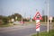 Typical European railroad crossing sign on a rural road indicating an unguarded level crossing soon, with its iconic black steam l