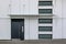 Typical facade with swing door, canopy and windows at the entrance of residential building.