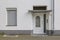 Typical facade with swing door, canopy and windows of residential building.