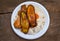 Typical food for Panama, banana slices, chicken, rice and vegetables, street sale served on a plastic plate, wooden background