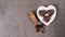 Typical German gingerbread cookies in heart shape on a white heart-shaped plate on a gray background. Traditional Christmas treat