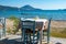 Typical Greek seaside tavern table with wooden chairs by the sea coast in Gialova near Pylos city, Messinia, Greece