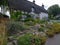 Typical Hampshire country cottage - half timbered and thatched - with pretty front garden in the village of Easton near Winchester