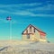 Typical Iceland family wooden house with flag on pylon
