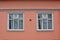 Typical Icelandic house facade in salmon pink color made of corrugated iron and with white wooden windows in Reykjavik