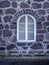 Typical Icelandic old style window in the black vulcanic stone wall