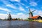 Typical iconic landscape in the Netherlands, Europe. Traditional windmills with a river in Zaanse Schans village. Famous tourist