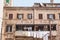 Typical italian mediterranean facade of a residential building, old and decaying with traditional laundry drying on windows