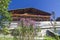 Typical mountain building in stone, white plaster and wood and with colorful flowers