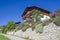 Typical mountain building in stone, white plaster and wood and with colorful flowers