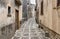 Typical narrow stone street in the medieval historical center of Erice, province of Trapani in Sicily.
