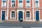 Typical Norman stone and brick house front with colorful contrasts and an Asian woman walking past