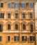 Typical old roman house facade with multiple windows ornaments.