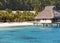 Typical Polynesian landscape - seacoast with palm trees and small houses on water