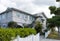 Typical Queensland house with tropical foliage and white picket fence on overcast day in Australia