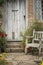 Typical quintessential old English country garden image of wooden chair next to vintage back door