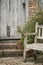 Typical quintessential old English country garden image of wooden chair next to vintage back door