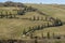 Typical rural landscape of the Tuscan countryside south of Siena, Italy, with cypresses bordering the dirt road