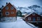 Typical scandinavian houses at fjord in front of snow covered mountains in winter