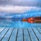 Typical scandinavian Red house on sea in fjord with platform dock in rainy day.