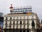 Typical sign of Tio Pepe on the roof of a building and the monument to King Carlos III in Puerta del Sol square. Madrid