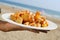 typical spanish patatas bravas, fried potatoes with a hot sauce, on the beach