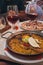 Typical spanish seafood paella in traditional pan. glasses with Spanish sangria in the background. dinner in a restaurant