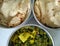 Typical stainless steel lunch box with indian food recipe chapati or roti and potato and spinach leaves vegitable selective focus