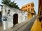 A typical street with cars, buses and motorcycles in the old town portion of Cartagena, Columbia early in a hazy morning