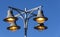 Typical street lamp on a pillar against a blue sky.