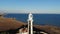 A typical striped lighthouse on the coast of the steppe area in the evening. Seashore steep aerial view