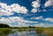 Typical summer lake scene, Belarus.Summer landscape with forest lake and blue cloudy sky. Summer landscape with Lake, beautiful bl