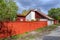 Typical swedish small residential house with wooden fence painted in traditional falun red in the cultural preserve at Vita Bergen