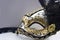 A typical Venetian carnival mask, gold with black, is reflected in the mirror