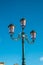 Typical Venetian lamppost with a blue background