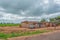 Typical village view, traditional terracotta houses with zinc plate cover and bricks, people and tropical landscape