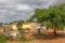 Typical village view, traditional terracotta houses with zinc plate cover and bricks, people and tropical landscape