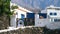 Typical white washed holiday rent house with vintage gates made of old wheels in Canary islands near ocean