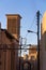 Typical Windtower made of clay taken in the streets of Yazd, iran, surrounded by power electrical lines.