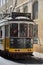 Typical Yellow Vintage Tram in Narrow Street of Lisbon, Portugal