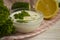 Tzatziki sauce, lemon,  greens  appetizer gastronomy nutrition cucumber on concrete background