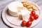 Tzfat cheese with crackers and cherry. Israeli traditional cheese. Symbol of the Jewish holiday Shavuot.