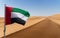 UAE flag and hypnotic patterns of sand desert in the UAE desert, near Dubai, UAE