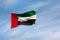 UAE flag waving in the sky, national symbol of UAE. UAE National Day.