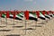 UAE National Flag Day. On a sandy beach, a composition of many flags