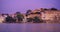 Udaipur Lal ghat, houses and City Palace on bank of lake Pichola at dusk at Udaipur, India. Horizontal panning