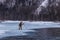 Udege hunter stands at the edge of the ice on the river